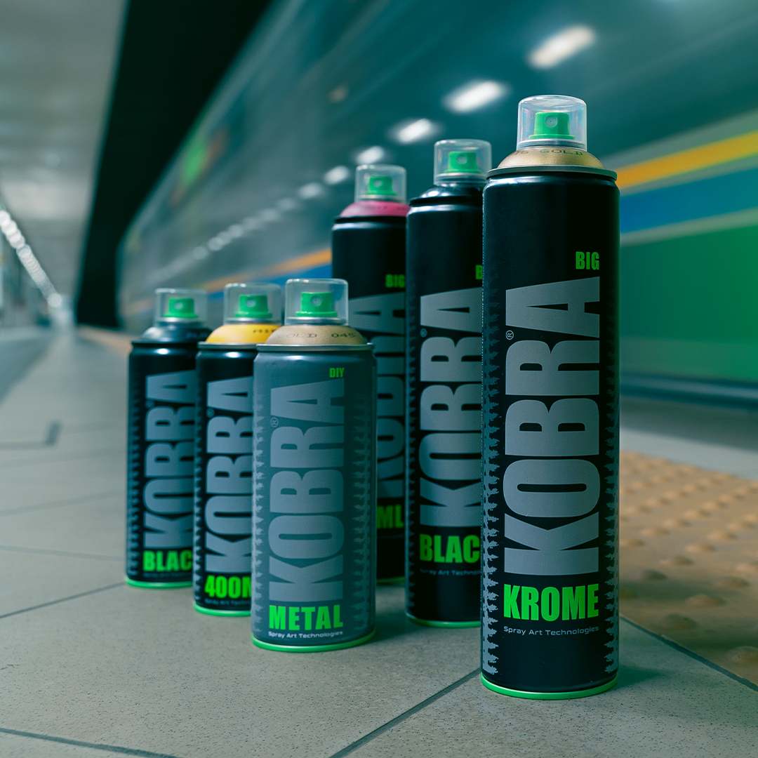 Kobra spray paint cans with a moving train in the background