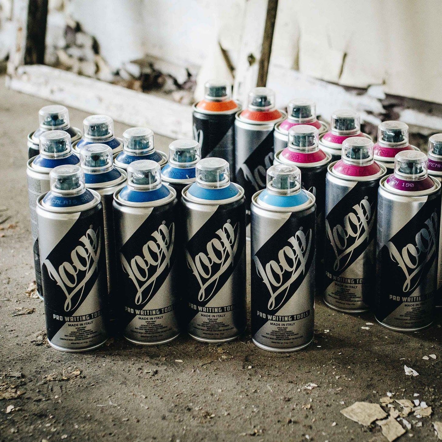 Unused Loop cans in multiple colours on a concrete floor.