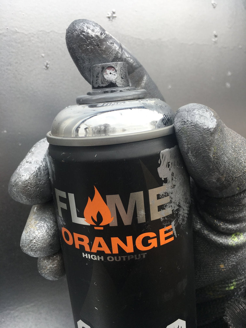 Flame orange high output spray paint can held in gloved hand