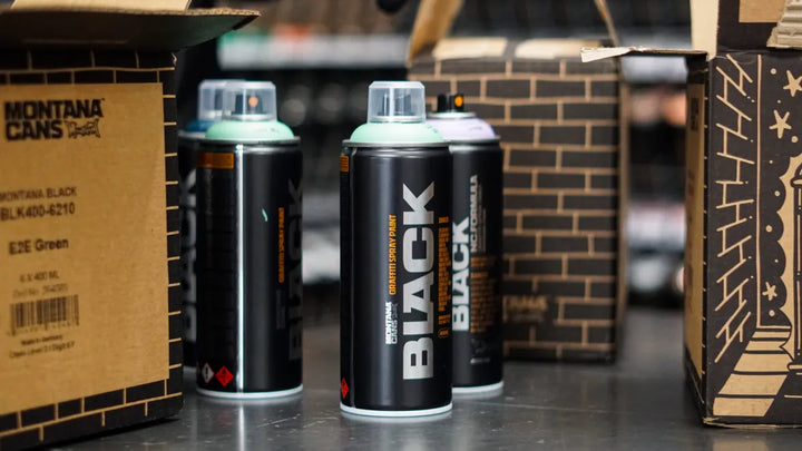 Montana cans lined up on a black background