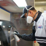 Person spraying car body part using Spray Max paint.